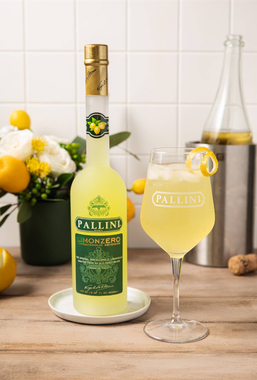 Pallini lemon liqueur bottle with a glass of lemonade on a wooden surface.