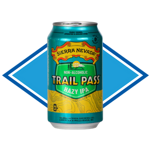 A 12 oz aluminum can of Sierra Nevada Trail Pass Hazy IPA non-alcoholic beer, featuring a teal, green, and yellow label with topographic line art, set against a blue and white diamond-shaped graphic background.