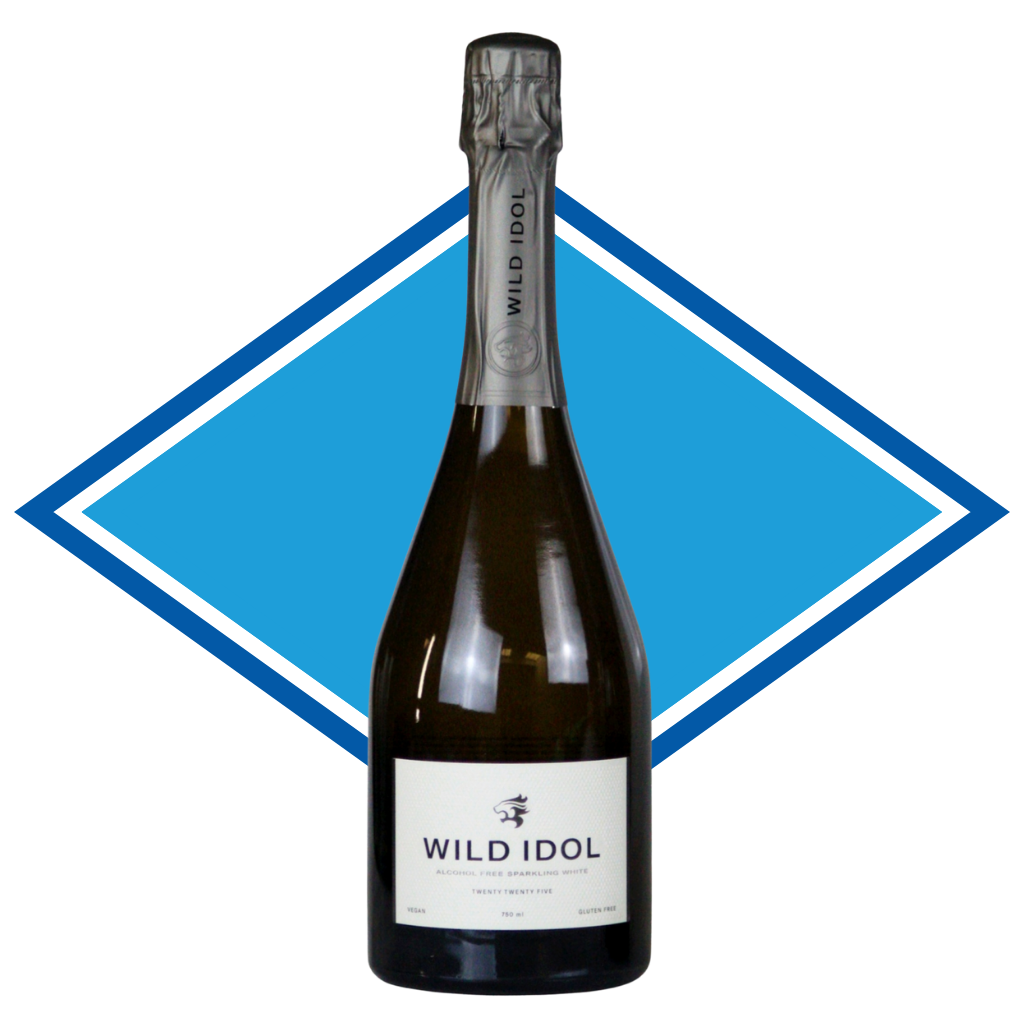 A bottle of Wild Idol sparkling wine with a white label and dark glass, centered against a blue diamond-shaped graphic background. Premium Non alcoholic Wine that is Halal certified